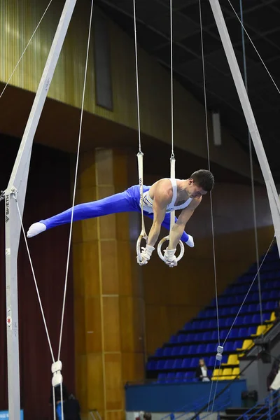 Αρσενικό gymnast εκτελεί την εν στάσει Γυμναστικά δαχτυλίδια — Φωτογραφία Αρχείου