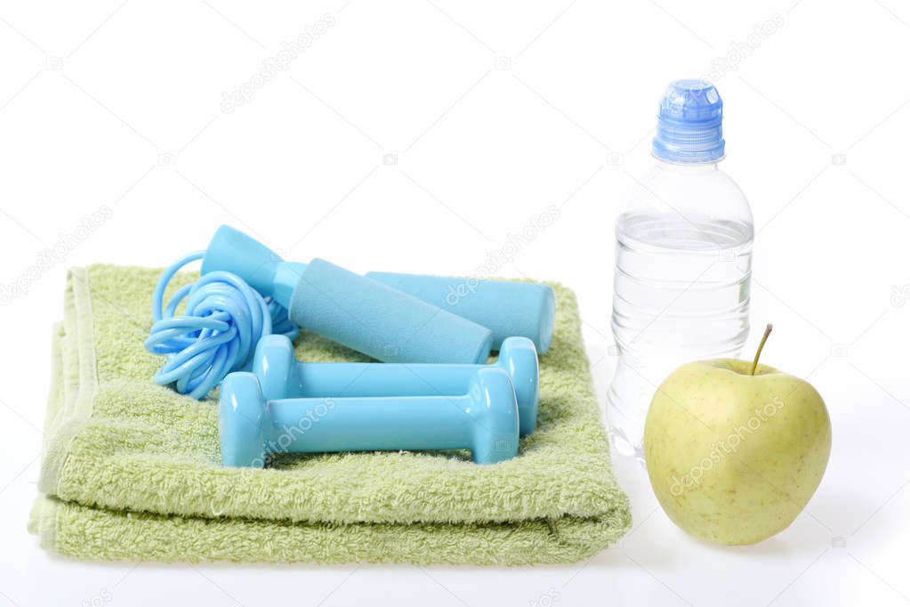 Gym time: cyan blue barbells and skipping rope on towel