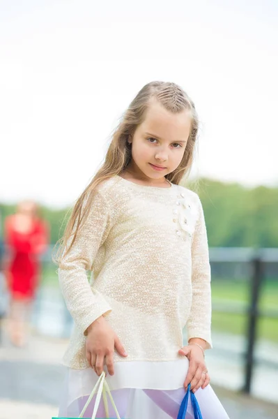 Söt liten flicka promenader med rosa shoppingväskor — Stockfoto