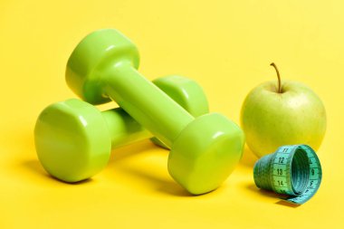 Apple dumbell ve ölçüm bandı yeşilimsi sarı renkte