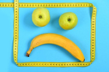 Meyve üzgün ifade ile yapılan yüz: muz ve elma