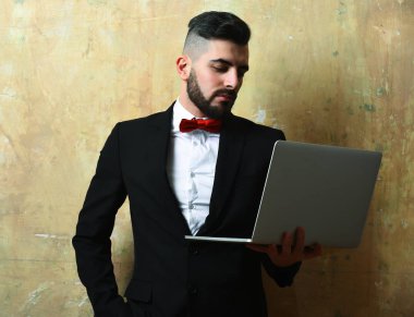 Ciddi yüz ifadesi ve dizüstü bilgisayarı olan finans ya da ofis yöneticisi