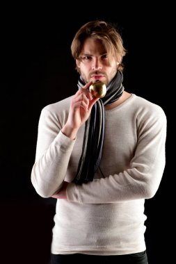 Çizgili eşarplı sakallı adam altın elmayı tutuyor.