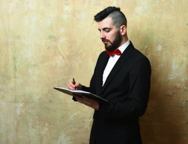 Ofis Yöneticisi sakal ve klasik takım elbise ile organizer içinde yazar