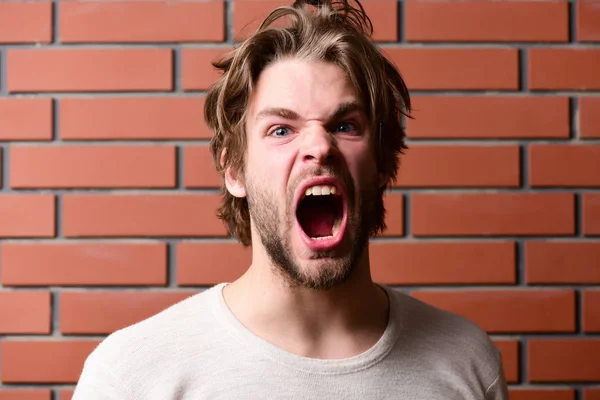 Homem machão brutal com barba, cabelo bagunçado e expressão louca — Fotografia de Stock