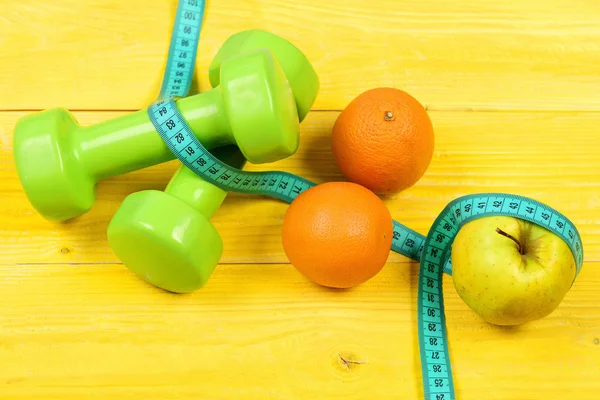 Uplatňovat koncept, hmotnost činky s měřicí pásky, pomeranč a jablko — Stock fotografie