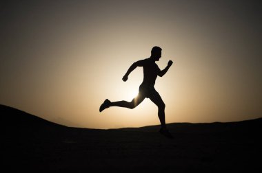 gün batımı, genç beyaz koşmak dağ içinde siluet koşan adam