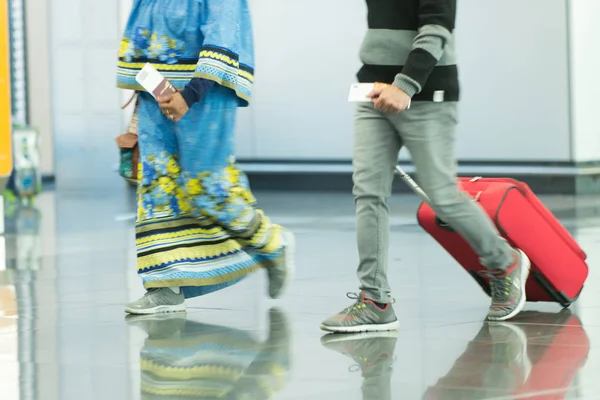 Люди з сумками та валізами в аеропорту — стокове фото
