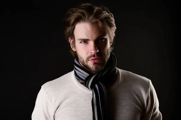 Мужчина с бородой и внимательным взглядом носит шарф с полосками — стоковое фото