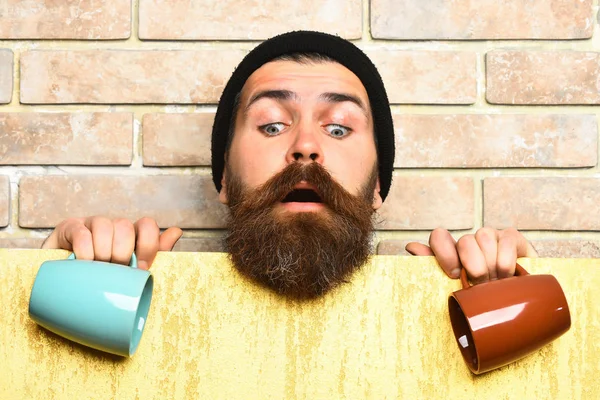 Barbudo brutal hipster caucásico con hoja de papel y tazas —  Fotos de Stock