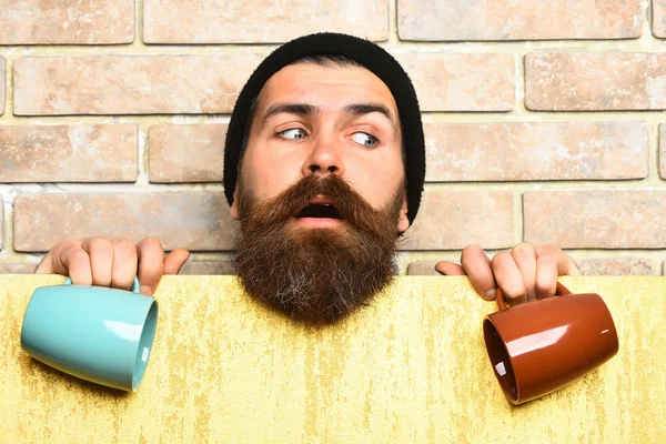 Barbudo brutal hipster caucásico con hoja de papel y tazas —  Fotos de Stock