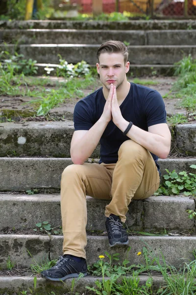Yüzünde konsantre bir ifade olan adam merdivenlerde oturur ve düşünür. — Stok fotoğraf