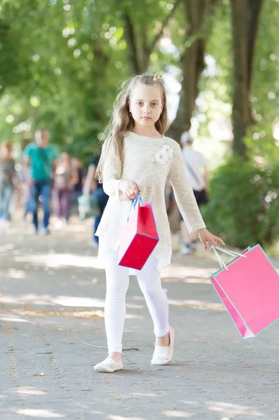 분홍색 쇼핑백을 들고 걸어가는 귀여운 소녀 — 스톡 사진