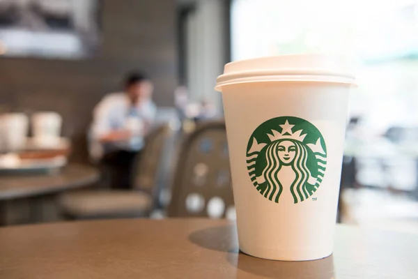 A tall Starbucks coffee cup in starbucks offee shop. — Stock Photo, Image