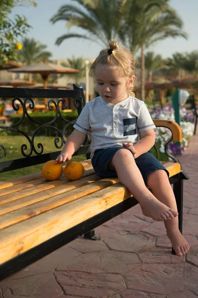 Happy kid or little boy barefoot with orange fruit — Stock Photo, Image