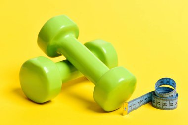 Mavi ve yeşil dumbbells bant ölçme bükülmüş
