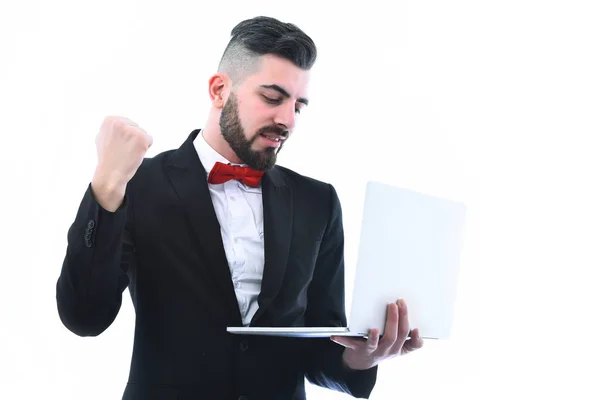 Бородатый бизнесмен в костюме с счастливым улыбающимся лицом держит компьютер — стоковое фото