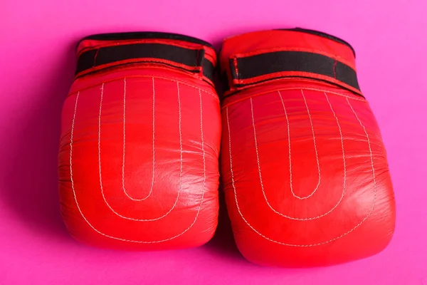 Guantes de boxeo en brillante nuevo color rojo aislado en rosa —  Fotos de Stock