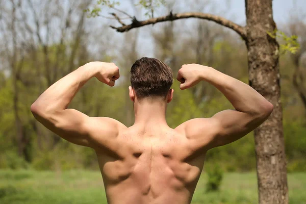 Los bíceps y los músculos de la espalda del hombre fuerte con corte de pelo elegante —  Fotos de Stock