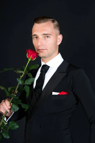 Ділова людина з квітка червоної троянди на чорному тлі — стокове фото