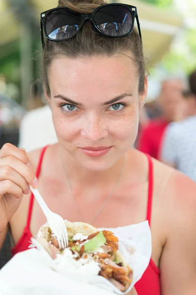 Feliz menina preatty ou mulher comendo giroscópios sanduíche. — Fotografia de Stock