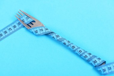 Turkuaz mavi mavi arka plan üzerinde izole bant ölçme çatalla