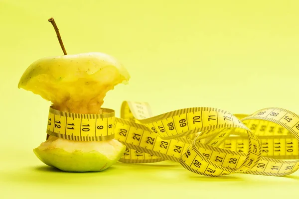 Tejp för mätning och bitten apple på gul bakgrund — Stockfoto