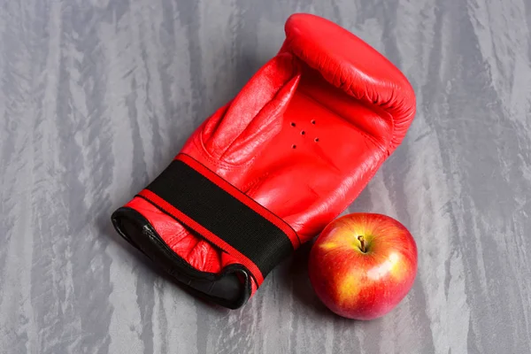 Pair of leather boxing sportswear with juicy red apple