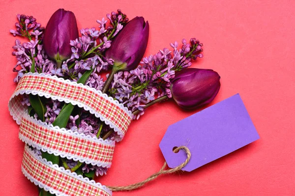 Buquê de primavera com tulipas e flores lilás com etiqueta roxa — Fotografia de Stock
