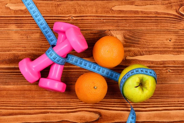 santimetre dumbell ağırlık ve elma, diyet kavramı için portakal ile
