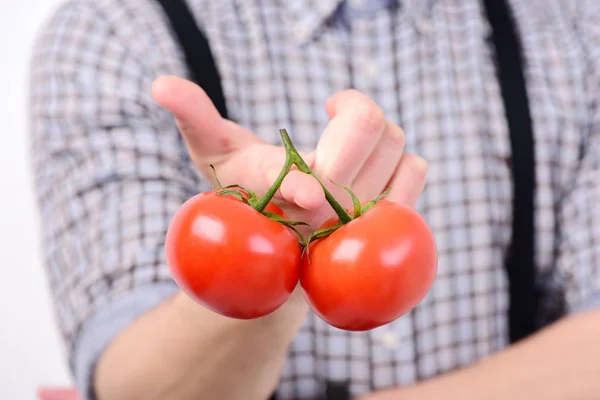 Schlanke Form und gesundes Ernährungskonzept. Mann hält rote Tomaten in der Hand — Stockfoto