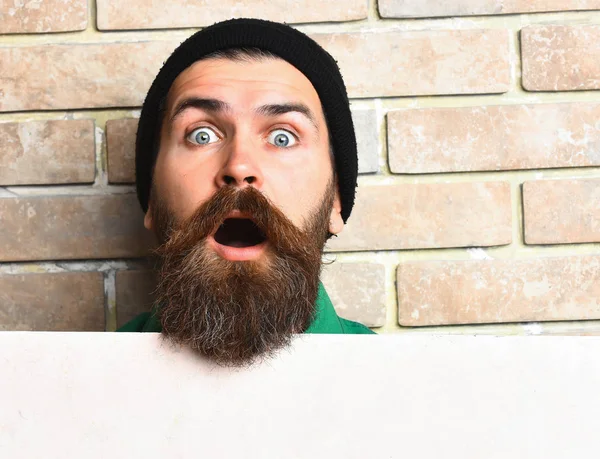 Bearded brutal caucasian hipster with white paper sheet — Stock Photo, Image