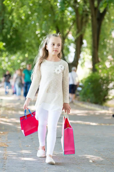 可愛い女の子がピンクの買い物袋を持って歩く — ストック写真