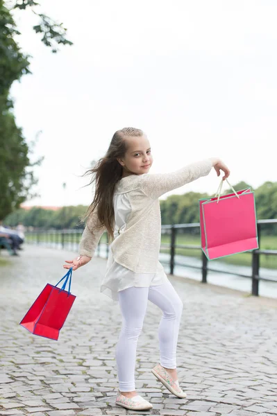 Menina bonito andando com os sacos de compras rosa — Fotografia de Stock