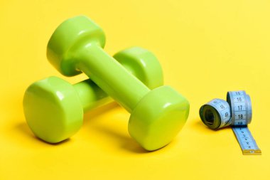 İzole sarı yeşil dumbbells ile mavi esnek cetvel