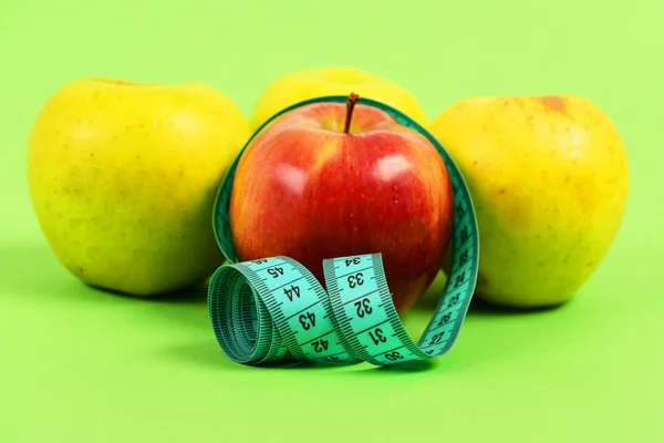 Sammansättningen av fyra äpplen och tejp för att mäta — Stockfoto