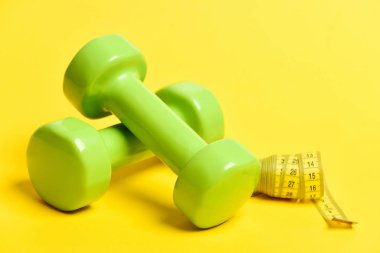 Hafif dumbbells yeşil ve sarı bant ölçme tüpü haddelenmiş