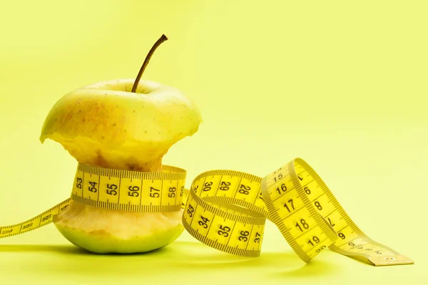 Hälsa och vikt management koncept: bitten äpple med flexibel linjal — Stockfoto
