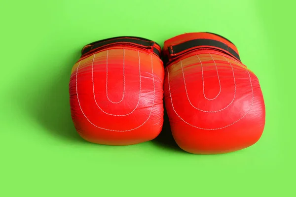 Sports gloves for boxing in red color on bright green