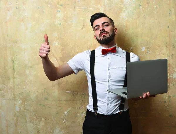 Werkgever met baard in wit shirt en strik met laptop — Stockfoto