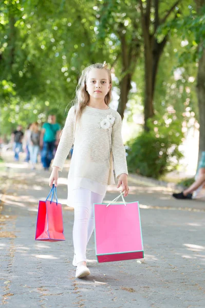 Pembe alışveriş torbalarıyla yürüyen tatlı küçük kız.