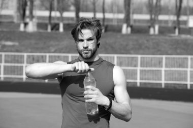 yakışıklı kaslı adam su şişesi tutan