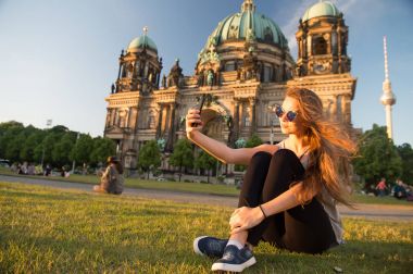 Berlin Katedrali 'nin önünde oturmuş selfie çekiyordu.