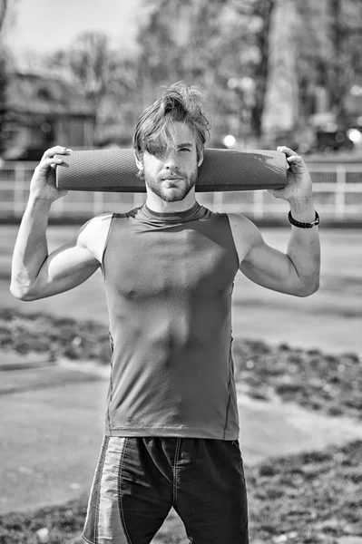 Yoga, colchoneta de fitness color azul en manos de hombre musculoso —  Fotos de Stock