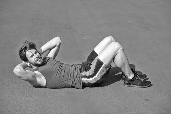 Atletisk skægget mand med muskuløs krop laver øvelser for abdo - Stock-foto