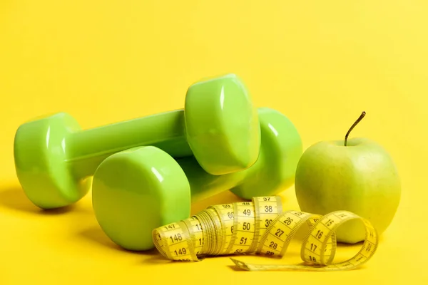 Sombrillas en color verde brillante, manzanas y cinta métrica larga — Foto de Stock