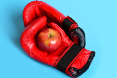Eğitim ve fitness kavramı. Kırmızı elma ile boks eldivenleri