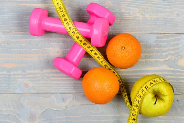 dieting food concept, dumbbells weight with measuring tape ,fruit