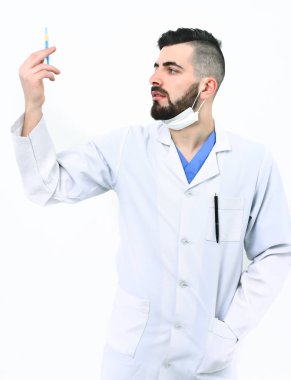 Sakallı dişçi şırıngayı tutuyor ve dikkatlice bakıyor.