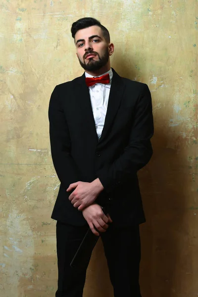 Man in suit and bow tie holds bottle of wine — Stock Photo, Image